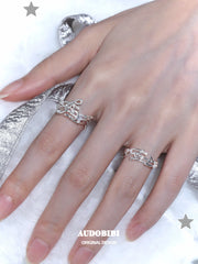 Musical-note open-ring designs, shown on the hand or wrist with other jewelry.